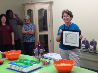 Dorothy Minor pictured with certificate of retirement while staff look on