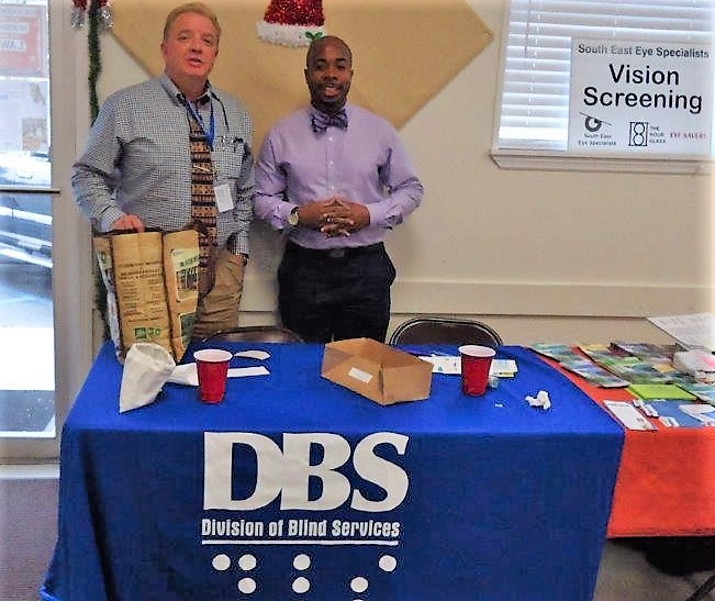 Rashad Morgan and Steve Adams standing behind a DBS display table