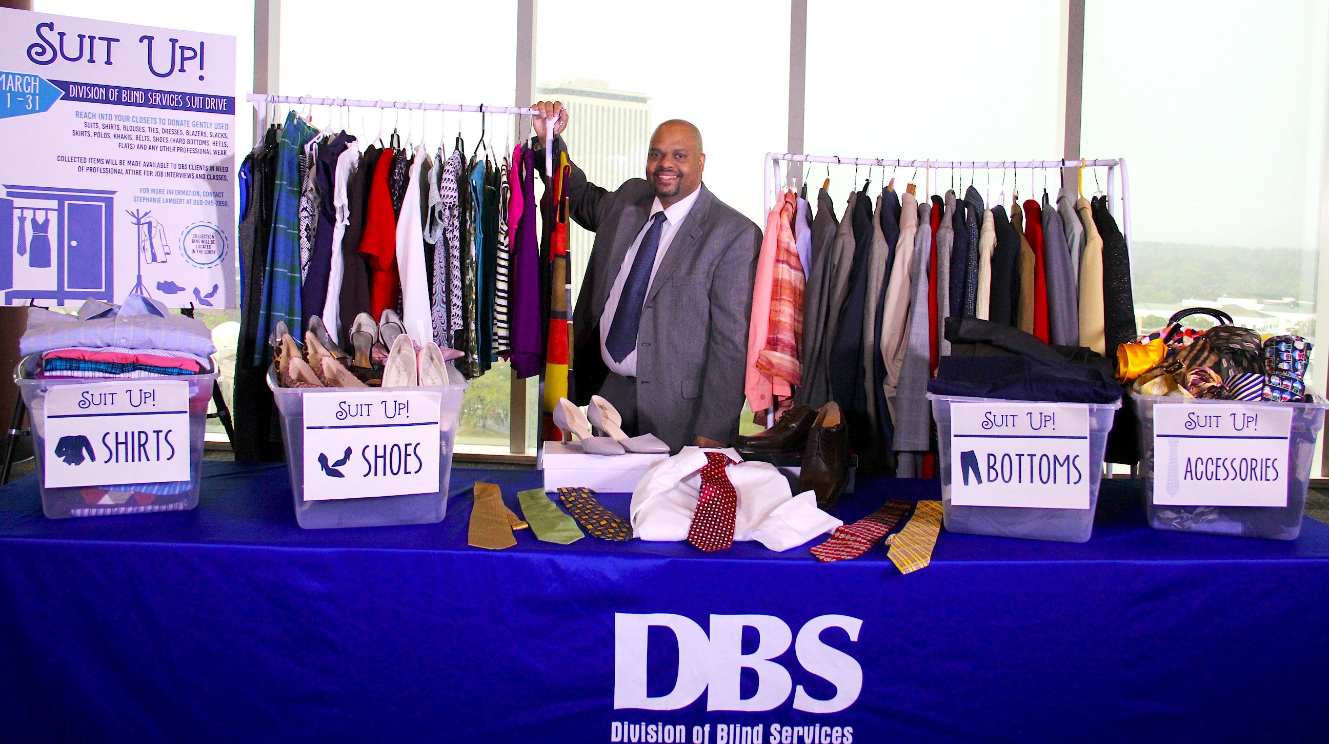 Florida Division of Blind Services Director Robert L. Doyle III standing with a few of the donated items