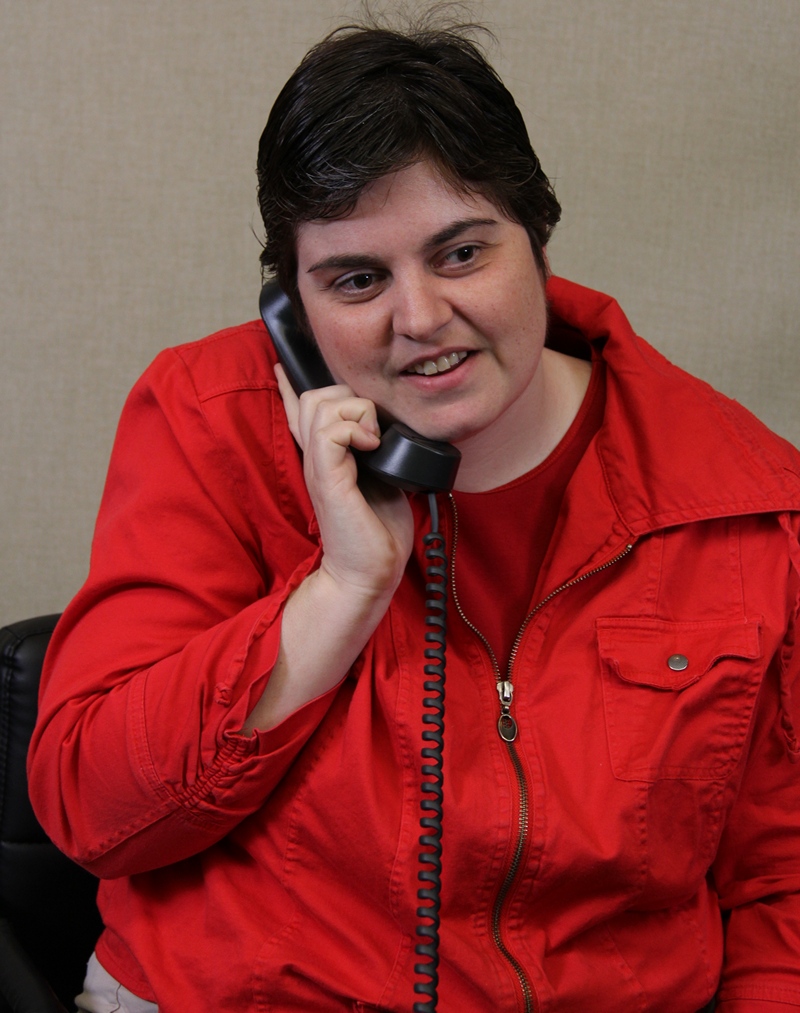 Woman in a red shirt uses her telephone 