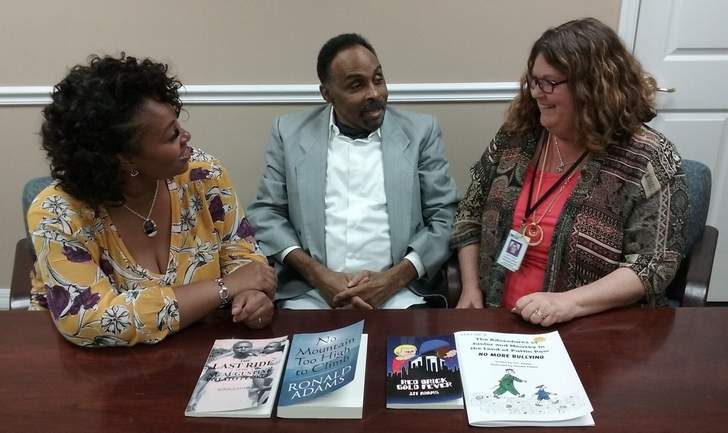 Palm Coast author Ronald Adams talks with friends Katherine Jefferson, left, and Terri Titus, the senior rehabilitation specialist who helped Adams, who is legally blind, get a computer to help him with his writing 