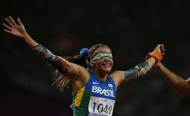 Brazil's Terezinha Guilhermina crosses the finishes line and celebrates winning the women's 100 meters