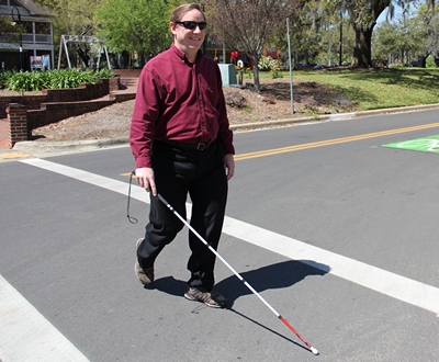 Adam Gaffney crossing street with cane.