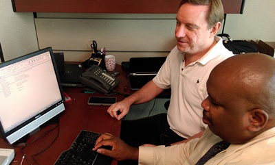Adam Gaffney and Walter Blackmon using a computer equipped with screen reading software.