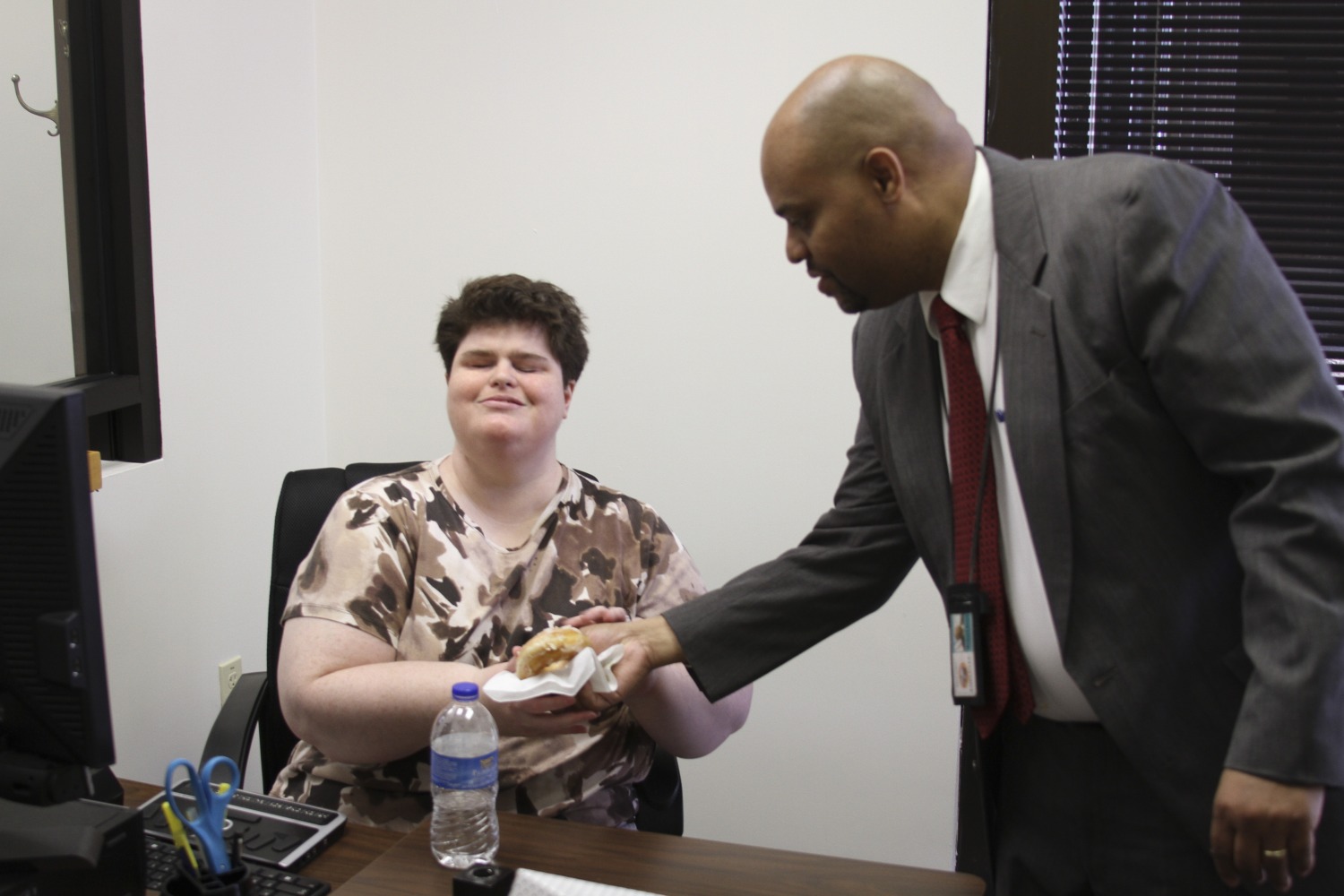 Director Doyle giving a donut to a staff member in the Tallahassee District Office