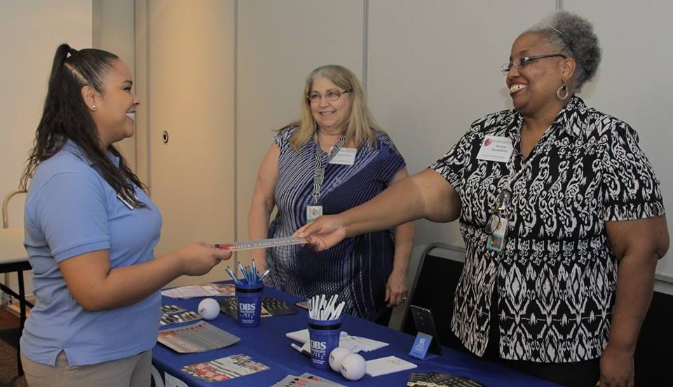 Young women visits the the DBS exhibit table  during the 75th Anniversary Ceremony and Expo.