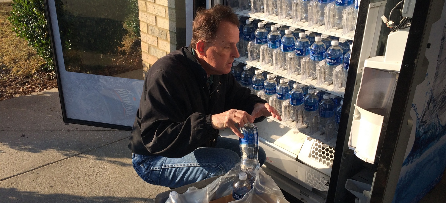 Don Tuell adding bottled water to a vending machine