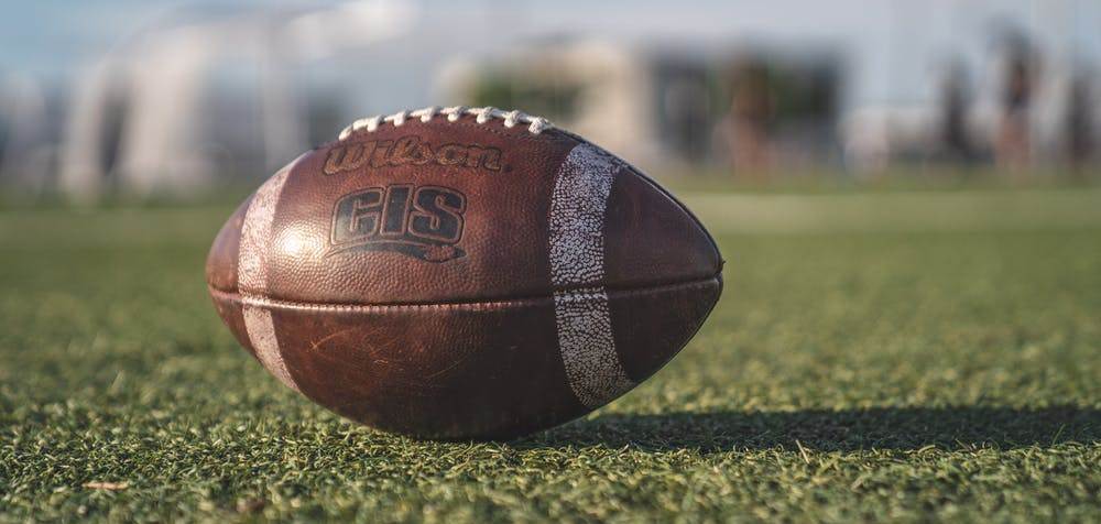 Image of a football on a grassy field.