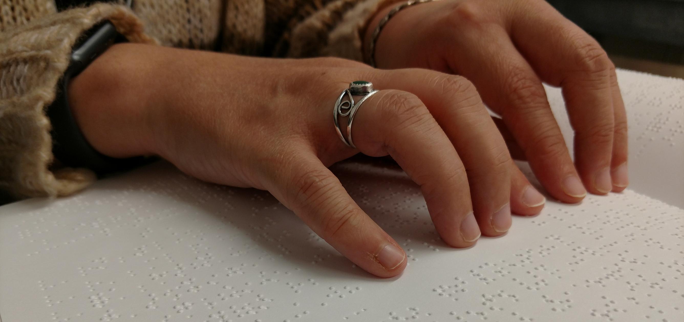 Hands reading Braille.