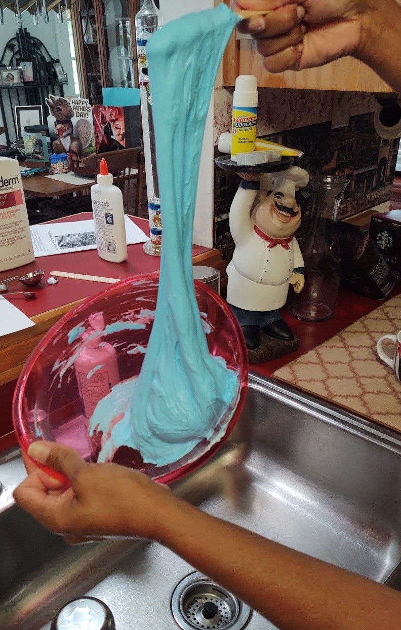 Slime pouring off a stick into a bowl beneath it.